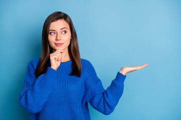 Photo of young attractive thoughtful lovely positive girl thinking hold hand demonstrate product isolated on blue color background