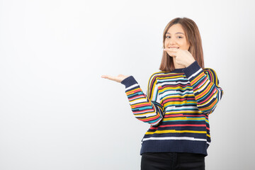 Portrait photo of a young woman model pointing at hand