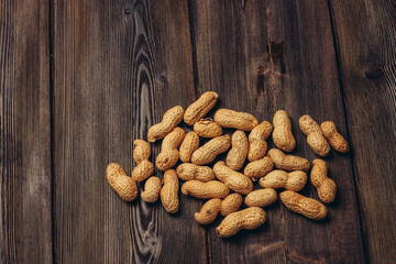 scattered peanuts in shells on a wooden table top view beer snack