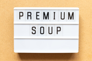 Lightbox with word premium soup on wood background