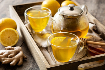 Ginger tea with lemon and honey in crystal glass on a tray