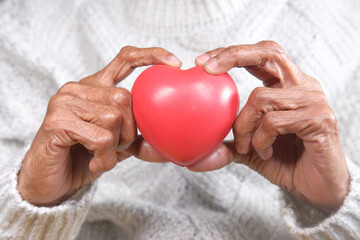 Obraz premium senior women holding red heart close up 