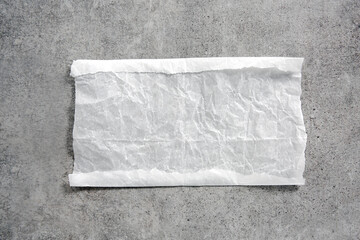 White paper napkin on grey stone table top view,food advertisement element,empty space blank.Baking paper piece.