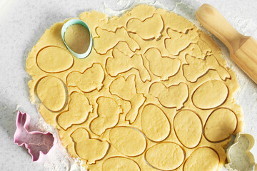 Dough with cookie cutters and rolling pin on kitchen table