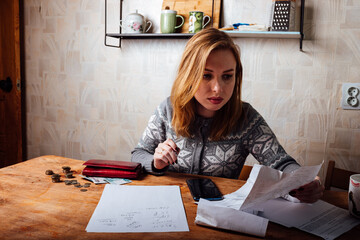 the girl counts the money in her wallet. filling out a tax return and calculating utility bills