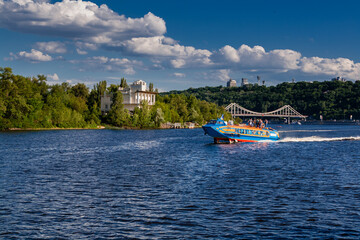 Speedboat sails on the river against the beautiful sky