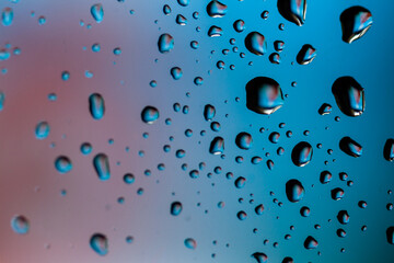 Beautiful multi-colored water droplets on a glass