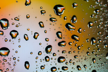 Beautiful multi-colored water droplets on a glass