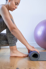Fototapeta premium woman picking up the mat after yoga training