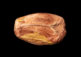 Close-up of fresh pistachio nuts on a black background.
