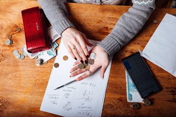 the girl counts the money in her wallet. filling out a tax return and calculating utility bills