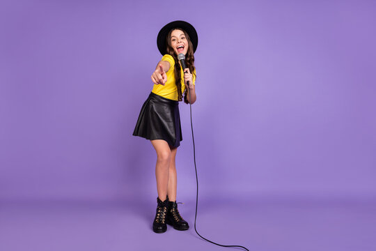 Full size photo of nice optimistic brunette hairdo girl sing in mic wear cap t-shirt skirt isolated on lilac background