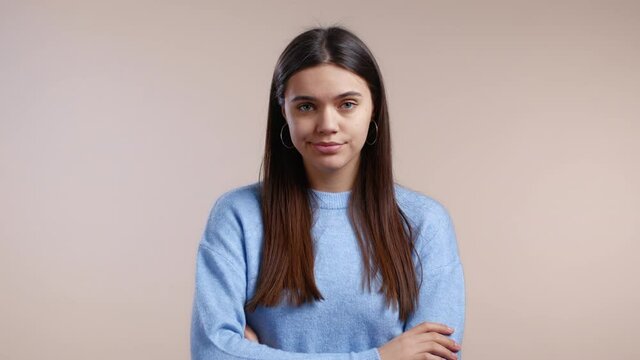 Portrait of tired girl, she exhales from disappointment. Light studio background. Young bored woman is dissatisfied, unhappy.