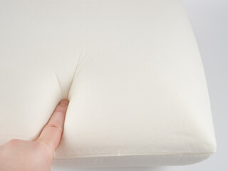 Orthopedic pillow, memory foam. Handprint on the pillow. Comfortable bedding with orthopaedic, therapeutic effect. Memory foam material.