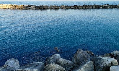 Mare Adrriatico calmo e azzurro e scogliera illumimati dal sole invernale