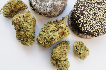 Marijuana blooms and sweets isolated on white background. Cannabis flowers and cookies close up. Hemp recreation, canna kitchen, pastime, legalization concept.