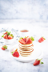 Pancakes decorated with strawberries in a plate