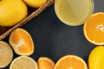 Fresh lemonade and fresh orange on the dark stone table, healthy drink, top view, copy space.