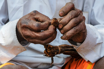 Subai, India - February 2021: A man making a cigar at the weekly market in Subai on February 22,...