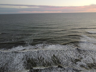 sunset in the atlantic ocean coast of argentina. waves with foam and beautiful sky colors