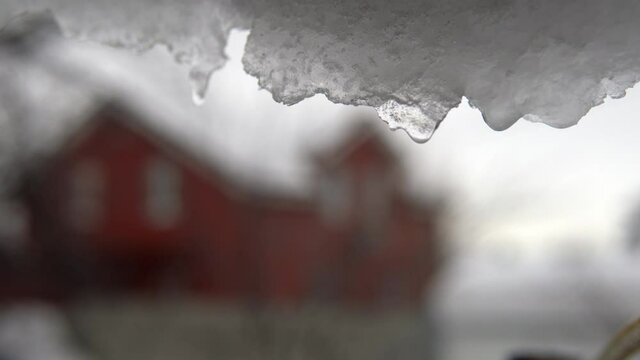 It's spring outside and the snow is melting against the background of a red house
