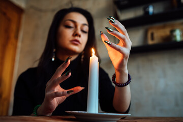 the girl is guessing on a lighted candle and cards, predicting the future and fate
