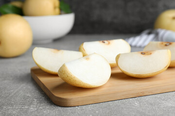 Slices of ripe apple pear on grey table