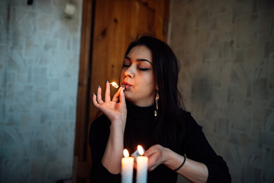 a girl fortune teller lights candles to predict the future. mystical ritual of communication with spirits