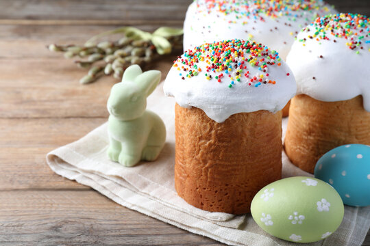 Beautiful Easter cakes with painted eggs and bunny on wooden table