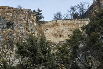 Fototapeta premium view of the ruins of an ancient ancient fortress wall between the rocks