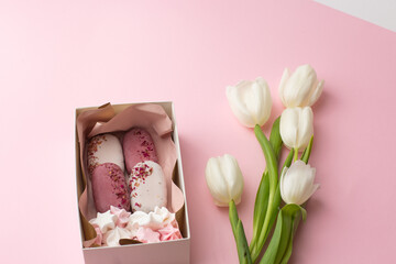 Delicious handmade ice-cream in a gift box isolated on pink background with white tulips. Sweet present, beautiful flowers, pink colors, flat lay. International women's day, birthday.