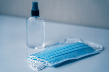 Hand sanitizer with antiseptic for hand hygiene and surgical masks to protect against coronavirus. Corona virus COVID-19 spread protection. Soft focus