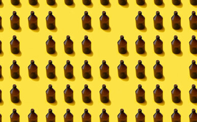 Fototapeta na wymiar Empty brown medicine glass bottle of cosmetic liquid on bright yellow background. Concept of the organic, zero waste cosmetics. Pattern seamless
