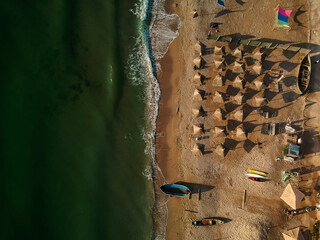 Aerial view of amazing beach with umbrellas and turquoise sea at sunrise. Black Sea at Vama Veche, Romania