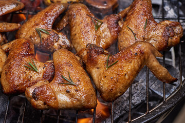 Grilled chicken wings on the flaming grill with Grilled vegetables in barbecue sauce with pepper seeds rosemary, salt. top view with copy space. tasty snack. Flat lay. Healthy lunch menu. Diet food.