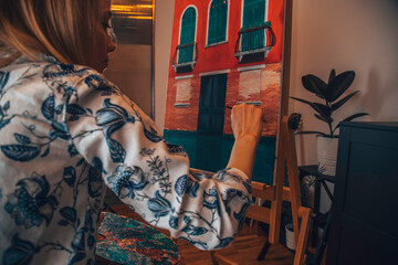 Talented female artist painting at her home.