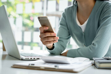 Women work at home and use smartphones and laptops to communicate, surf the internet or shop online, work from home concept.