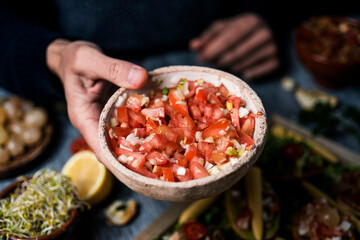 man with a tomato salad and vegan appetizers