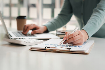Businessman is inspecting the business reports graphs to audit the financial reports. Analyzing the...