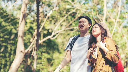 Tourist and traveler asian couple backpack enjoy and happy the jungle forest nature park . Traveler going camping and explore outdoors destination leisure