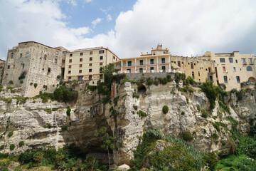 Fototapeta na wymiar Historical coastal harbour town Tropea with houses located on steep cliffs, popular holiday touristic place in Calabria, Italy