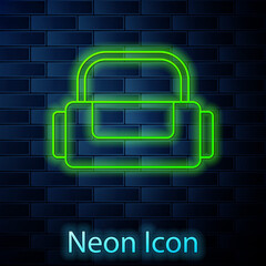 Glowing neon line Sport bag icon isolated on brick wall background. Vector.