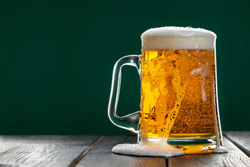 Beer is poured out of glass. Mug with traditional Irish ale on a dark background.