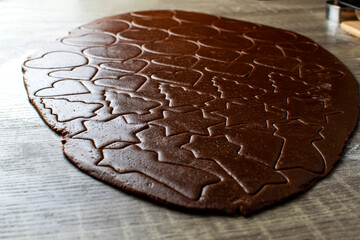 the shape of a heart in a ginger dough that lies on a wooden table. Baking concept