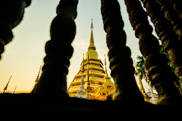 Ancient Golden Pagoda with Wooden Balustrade Foreground in Wat Phan Tao