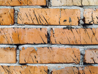 The texture of an old wall of red, orange uneven bricks. Vintage, grunge background.
