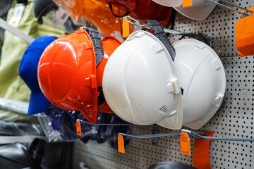 Construction helmets of different colors in a shop window. Close-up