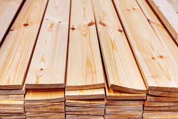 Pine board in a warehouse of a hardware store. Processed wood for sale in the wholesale and retail network. Close-up. Copy space