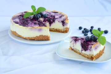 Blueberry cheesecake with mint leaf on white background
