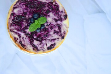 Blueberry cheesecake with mint leaf on white background